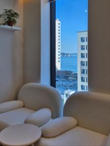 a room with two chairs in front of a window at 로프트부산 loft busan in Samgong