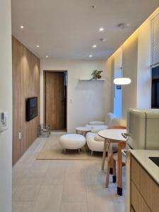 a room with tables and chairs and a kitchen at 로프트부산 loft busan in Samgong