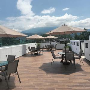 a patio with tables and chairs and umbrellas on a roof at Hotel RINCON RESORT TEQUILA in Tequila