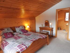 a bedroom with a bed and a wooden ceiling at Chalet Le Murier in Leysin +2 photos