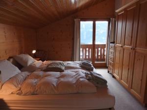 a large bed in a room with a window at Chalet Le Murier in Leysin