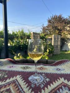 a glass of white wine sitting on a table at Nebi Winery in Chʼardakhi