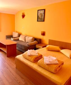 a living room with two beds and a couch at Hotel Restaurant Vodenitsata in Berkovitsa