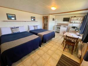 a hotel room with two beds and a kitchen at Chalets Camping Bernatchez in Mont-saint-pierre