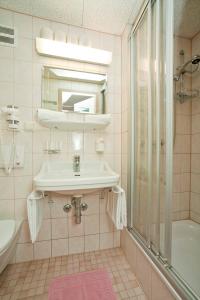 uma casa de banho com um lavatório e um chuveiro em Gasthaus Mitterjager em Kirchdorf in Tirol