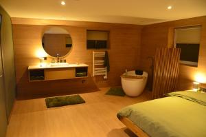 a bedroom with a bathroom with a tub and a sink at Horizon d'or in Profondeville