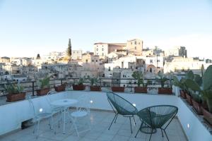 a balcony with chairs and a table and a city at Lo splendore dei Sassi in Matera