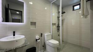 a white bathroom with a sink and a toilet at Ahiva Suites Goidhoo in Fehendhoo +20 photos