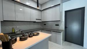 a kitchen with white cabinets and pots and pans on a counter at Ahiva Suites Goidhoo in Fehendhoo