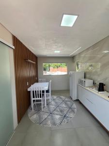 a kitchen with a white table and a white refrigerator at Recanto do Sol in Governador Celso Ramos +16 photos