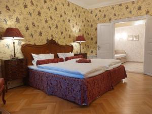 a bedroom with a large bed with floral wallpaper at Hotel Goldener Anker in Bayreuth +42 photos