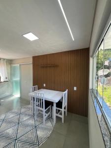 a dining room with a white table and chairs at Recanto do Sol in Governador Celso Ramos