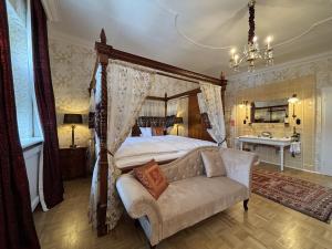 a bedroom with a canopy bed and a couch at Hotel Goldener Anker in Bayreuth
