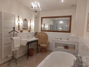 a bathroom with a tub and a sink and a mirror at Hotel Goldener Anker in Bayreuth