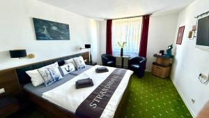 a hotel room with a large bed and a chair at Strand-Hotel Lobbe in Lobbe +22 photos