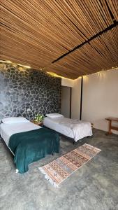 two beds in a room with a wall at Natural Luxury Birding Lodge - Premium Birdwatching near Cali in Papagalleros