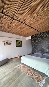 a bedroom with a bed with a wooden ceiling at Natural Luxury Birding Lodge - Premium Birdwatching near Cali in Papagalleros