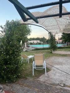 a couple of chairs sitting in a yard at Villa Paula II in Ranchos