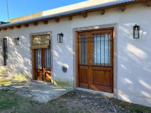 a white house with two wooden doors on it at Villa Paula II in Ranchos