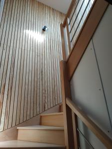 a stairwell with a wooden wall and a wooden stair case at Appartement meublé, Le 37bis in Bolbec