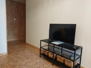 a flat screen tv sitting on top of a black stand at Appartement meublé, Le 37bis in Bolbec