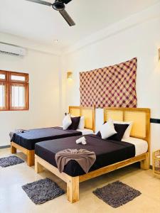 a bedroom with two beds with blue sheets at Edwin's Ahangama in Ahangama