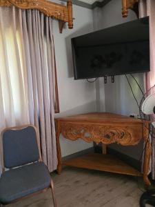a room with a tv and a wooden table and a chair at La Leona Homestay in Hernani +25 photos