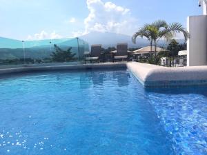 a swimming pool with chairs and a table and mountains at Hotel RINCON RESORT TEQUILA in Tequila
