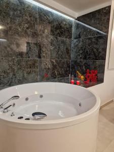 a bath tub in a bathroom with a black wall at Cenvi Suite - Jacuzzi rooms in Mola di Bari