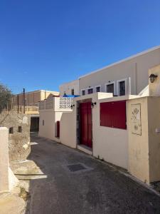 a building with a red door on a street at Arbarorisa Traditional Suites in Mesaria