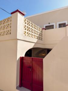a red door on a white building with a balcony at Arbarorisa Traditional Suites in Mesaria