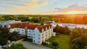 an aerial view of a building with a sunset in the background at AKZENT Hotel Frankenberg in Frankenberg