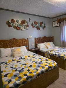 a bedroom with two beds and plates on the wall at La Leona Homestay in Hernani