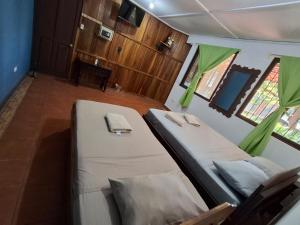 a bedroom with two beds in a room with windows at Hotel Marielos Tamarindo in Tamarindo