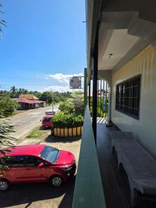 a red car parked on the side of a building at La Leona Homestay in Hernani