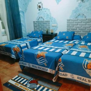 a bedroom with two beds with blue and white blankets at Don Mauricio y periquines in Robledillo +58 photos
