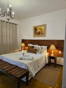 a bedroom with a large bed with a wooden headboard at Pousada Berço Mineiro in Tiradentes
