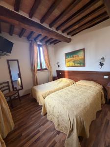 a hotel room with two beds and a mirror at B&B Fonte dei Tufi in Siena