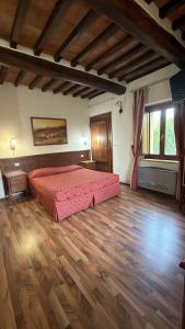 a bedroom with a bed and a wooden floor at B&B Fonte dei Tufi in Siena