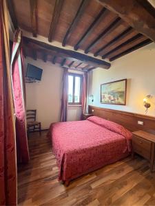 a bedroom with a red bed in a room at B&B Fonte dei Tufi in Siena +3 photos