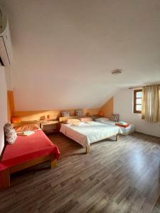 a room with two beds and a red couch at Adriana Guesthouse in Jezerce