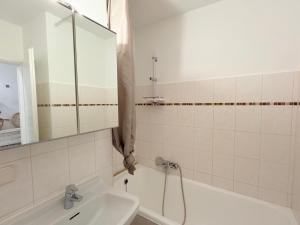 a bathroom with a sink and a tub and a mirror at Wohlfühl Apartment Bad Reichenhall nahe Salzburg in Bad Reichenhall