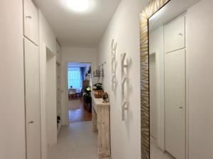 a hallway with white walls and a mirror at Wohlfühl Apartment Bad Reichenhall nahe Salzburg in Bad Reichenhall +3 photos
