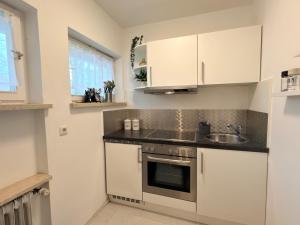 a kitchen with white cabinets and a sink at Wohlfühl Apartment Bad Reichenhall nahe Salzburg in Bad Reichenhall