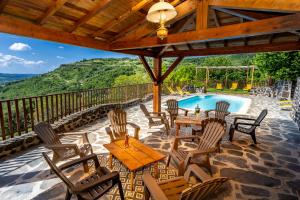 eine Terrasse mit Stühlen und einem Tisch sowie ein Pool in der Unterkunft Refuge au Monteillet in Saint-Gineis-en-Coiron