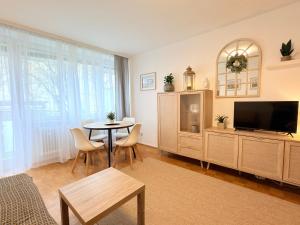 a living room with a table and a tv at Wohlfühl Apartment Bad Reichenhall nahe Salzburg in Bad Reichenhall