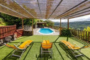 eine Außenterrasse mit Stühlen und ein Swimmingpool in der Unterkunft Refuge au Monteillet in Saint-Gineis-en-Coiron