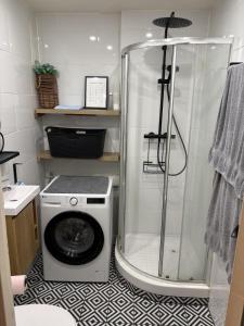 a bathroom with a shower and a washing machine at Studio à Gaillard in Gaillard