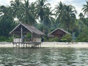 a shack on the shore of a body of water at Ina Homestay in Mios Besar