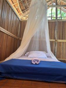 a canopy bed with a pair of pink donuts on it at Ina Homestay in Mios Besar